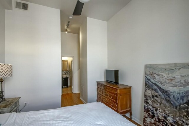 bedroom featuring ceiling fan, rail lighting, and light hardwood / wood-style floors