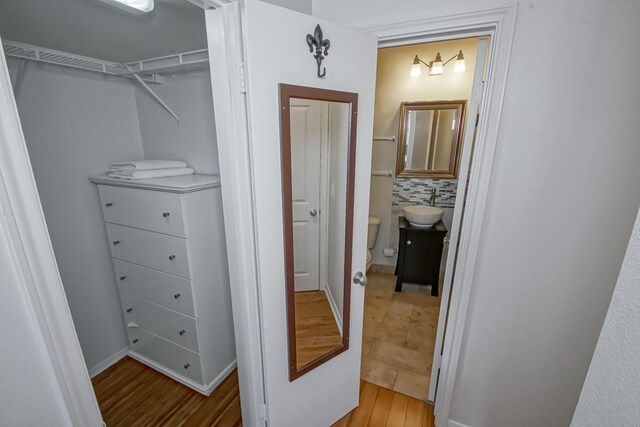 walk in closet featuring light wood-type flooring and sink