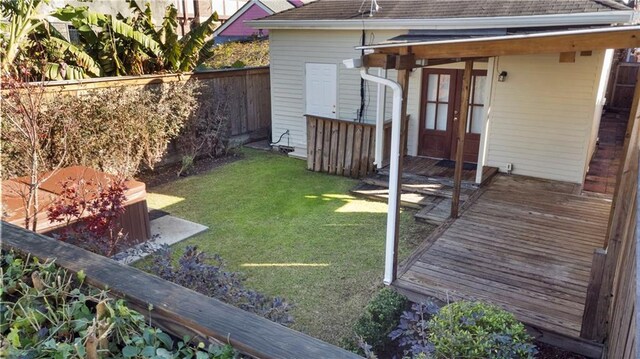 view of yard with a deck and a jacuzzi