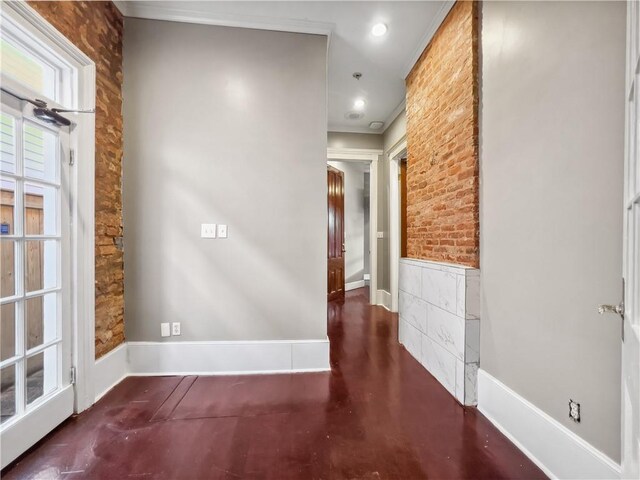 interior space with brick wall and crown molding