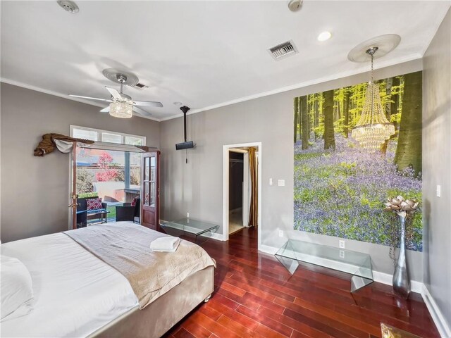 bedroom with ceiling fan with notable chandelier, dark wood-type flooring, ornamental molding, and a walk in closet