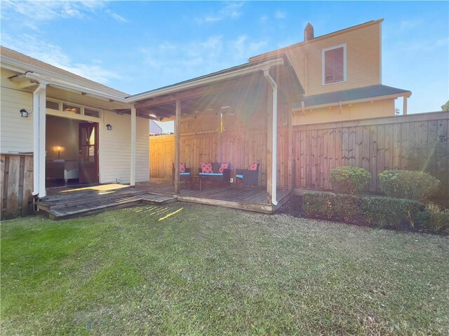 exterior space featuring a wooden deck and a lawn