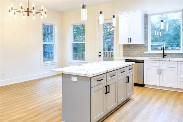 kitchen with white cabinetry, dishwasher, a kitchen island, pendant lighting, and sink