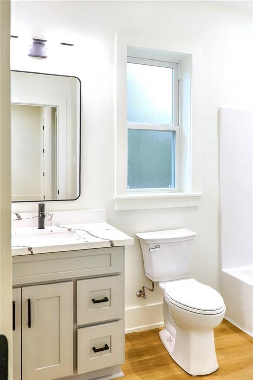 bathroom featuring toilet, hardwood / wood-style floors, and vanity