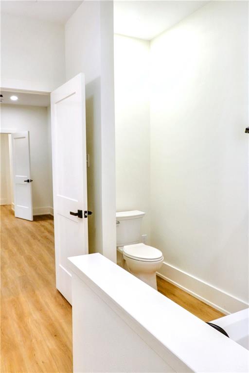 bathroom featuring toilet and wood-type flooring