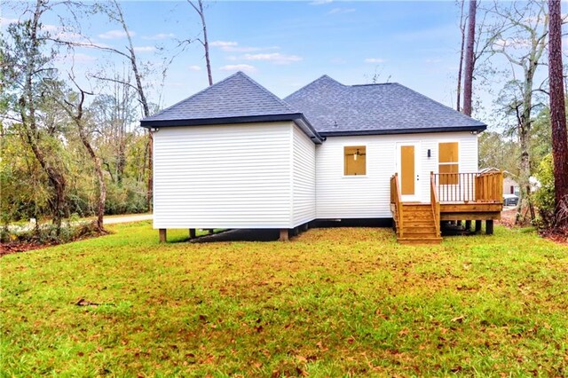 back of property featuring a lawn and a wooden deck