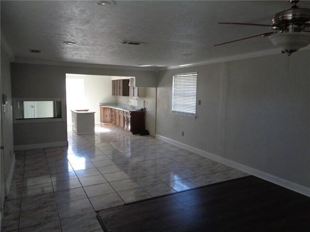 unfurnished room featuring ceiling fan, sink, and crown molding