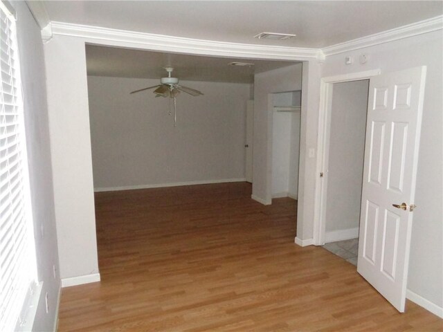 corridor featuring ornamental molding and light hardwood / wood-style floors