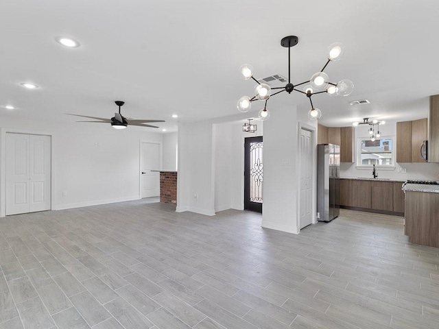 unfurnished living room with sink, light hardwood / wood-style flooring, and ceiling fan