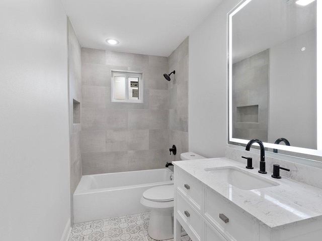 full bathroom featuring vanity, tiled shower / bath, tile patterned flooring, and toilet