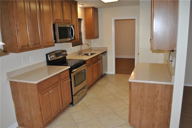 kitchen with light tile patterned flooring, stainless steel appliances, and sink