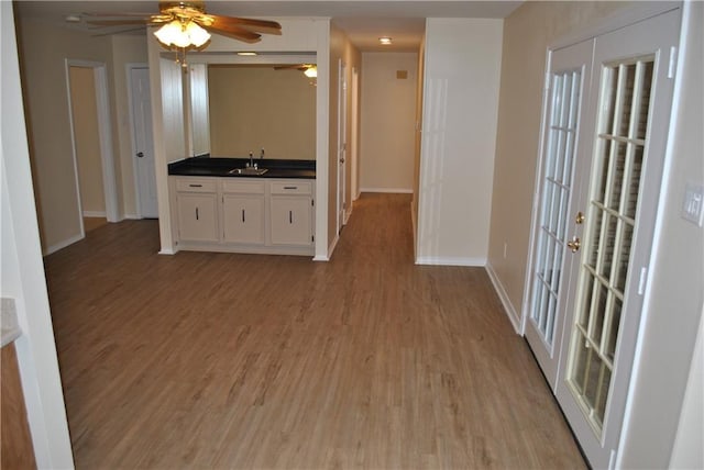 kitchen with white cabinets, sink, and light hardwood / wood-style floors