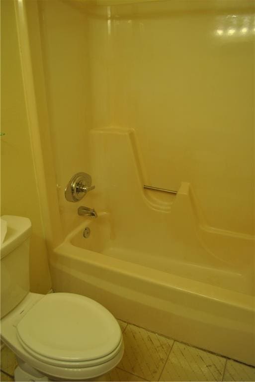 bathroom with toilet, tile patterned floors, and bathtub / shower combination