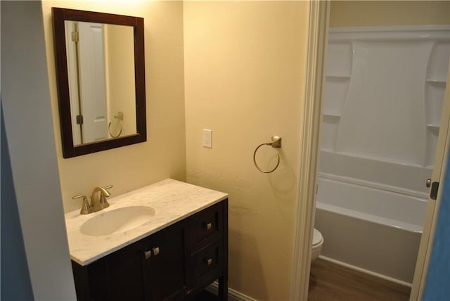 full bathroom with toilet, vanity, shower / washtub combination, and hardwood / wood-style flooring