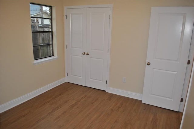 unfurnished bedroom with hardwood / wood-style flooring and a closet