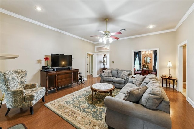 living room with hardwood / wood-style flooring, crown molding, and ceiling fan