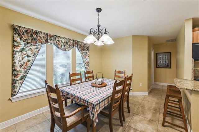 dining space with a healthy amount of sunlight, light tile patterned flooring, and an inviting chandelier