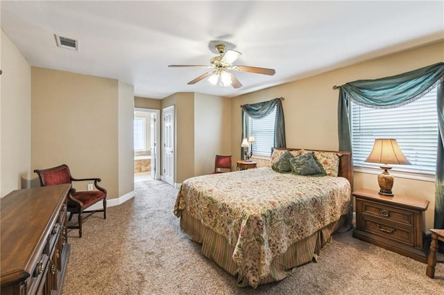 bedroom with ensuite bathroom, ceiling fan, light carpet, and multiple windows