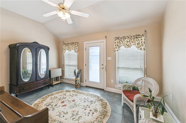 entrance foyer featuring vaulted ceiling, ceiling fan, and dark tile patterned flooring