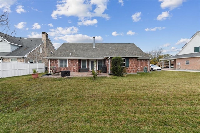 back of property with a yard and a patio