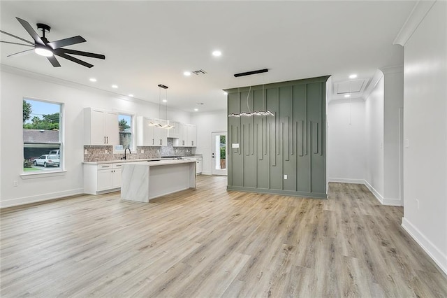 kitchen featuring a center island, tasteful backsplash, light countertops, open floor plan, and light wood-type flooring