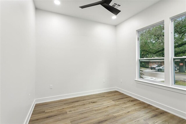 empty room with ceiling fan and light hardwood / wood-style flooring