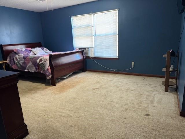 carpeted bedroom featuring a textured ceiling and cooling unit