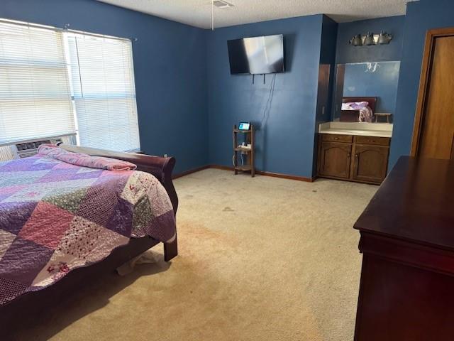 bedroom with light carpet and a textured ceiling