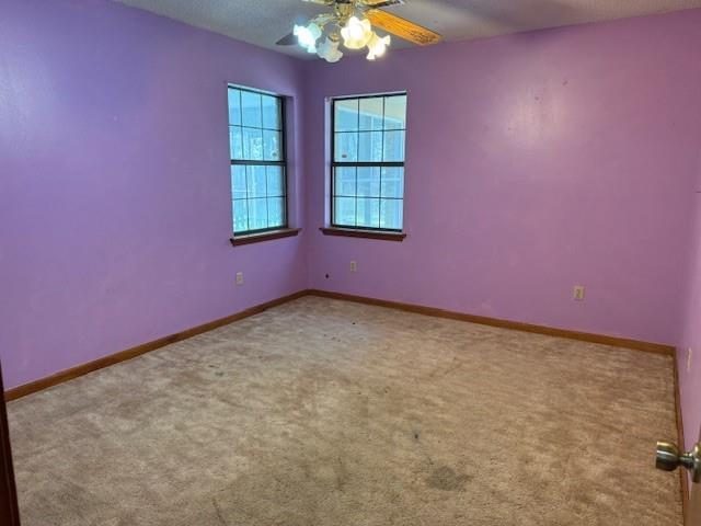 carpeted empty room featuring ceiling fan