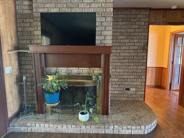 interior details with a brick fireplace and wood walls