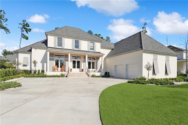 view of front of property featuring a front lawn, a garage, and a porch