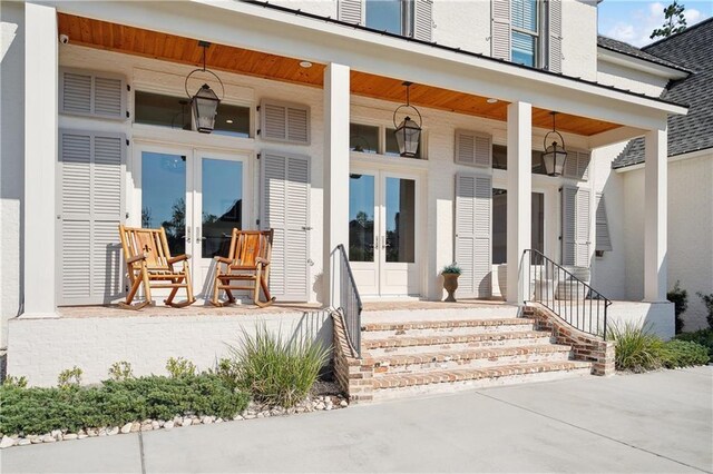 entrance to property with covered porch and french doors