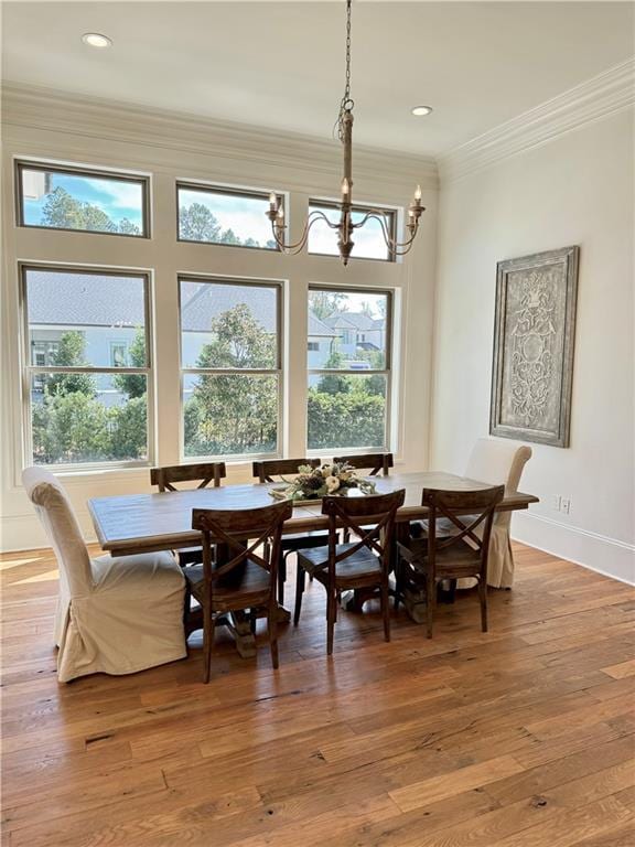 dining space featuring crown molding, a chandelier, and hardwood / wood-style floors