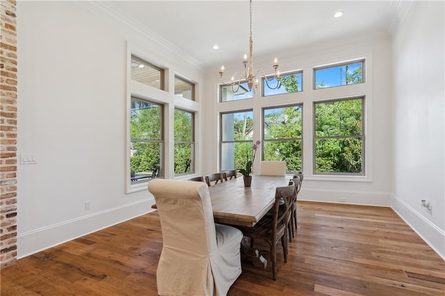 dining area featuring a chandelier, crown molding, and hardwood / wood-style floors