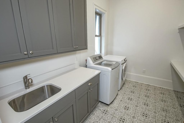 laundry room featuring cabinets, sink, light tile patterned floors, and washing machine and clothes dryer