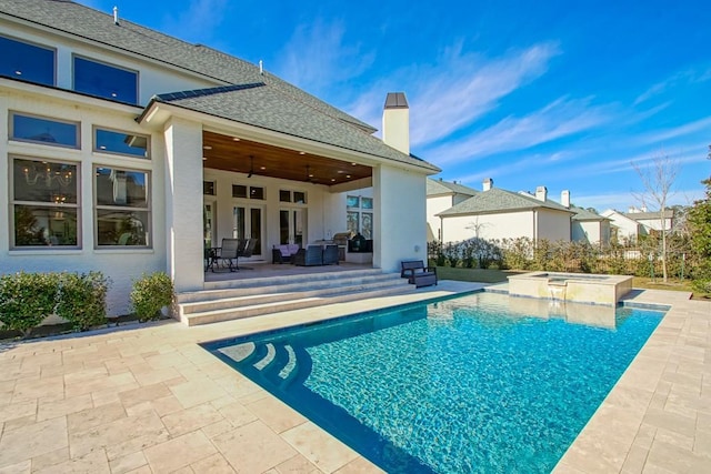 rear view of house with ceiling fan, a patio area, outdoor lounge area, a swimming pool with hot tub, and french doors