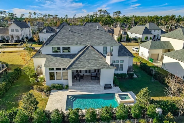 back of property featuring a pool with hot tub and a patio area