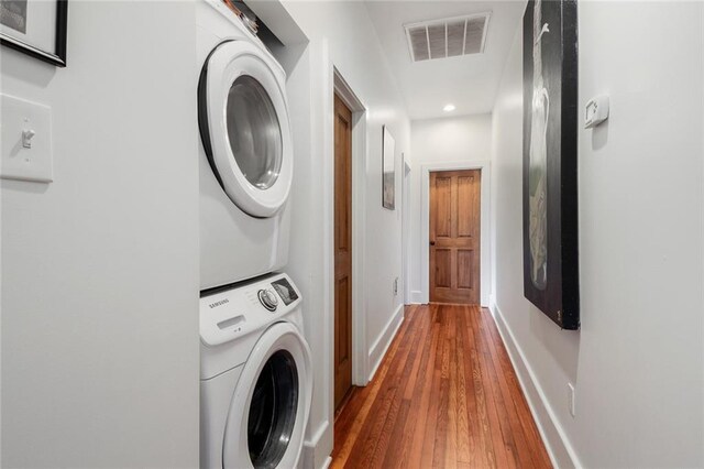 washroom with stacked washer / dryer and hardwood / wood-style floors