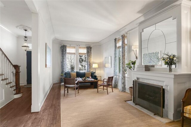 sitting room with hardwood / wood-style flooring and ornamental molding