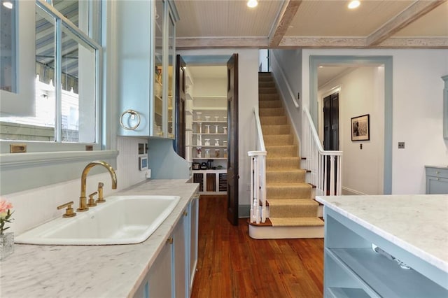 kitchen featuring light stone counters, sink, dark hardwood / wood-style floors, and ornamental molding