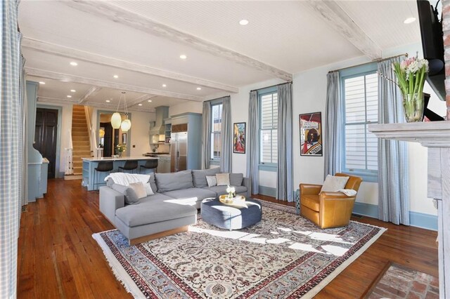 living room with dark wood-type flooring and beamed ceiling