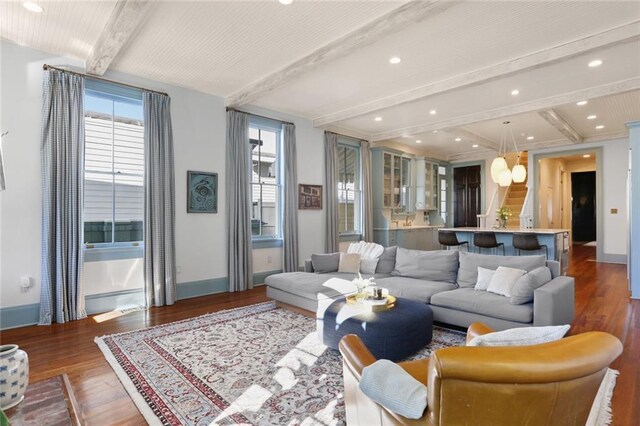 living room with dark wood-type flooring and beamed ceiling