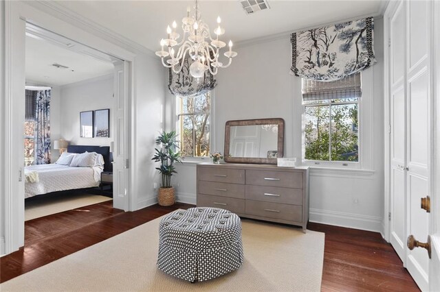 bedroom featuring dark wood-type flooring, a chandelier, and crown molding