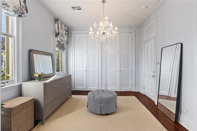 interior space with crown molding, dark wood-type flooring, and an inviting chandelier