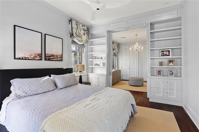 bedroom featuring dark hardwood / wood-style flooring, crown molding, and ceiling fan with notable chandelier