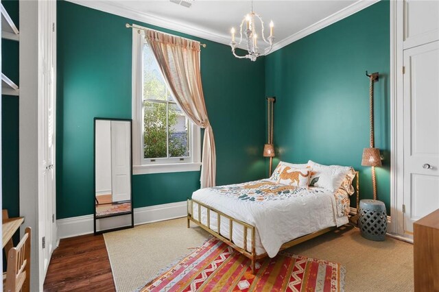 bedroom with dark wood-type flooring, crown molding, and a notable chandelier