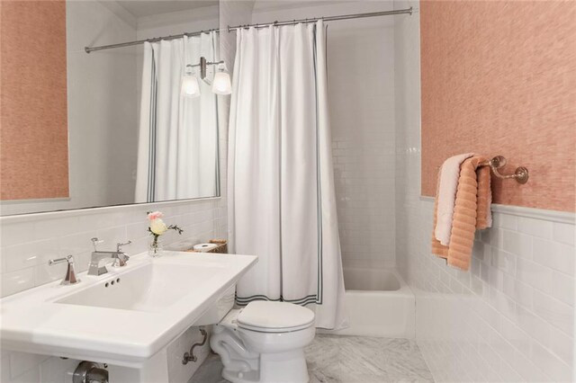 full bathroom with toilet, shower / bathtub combination with curtain, tile walls, and sink