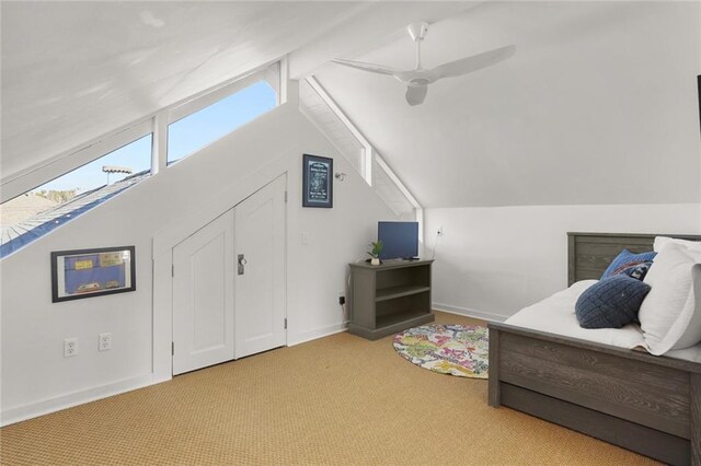 interior space with ceiling fan, lofted ceiling, and light colored carpet