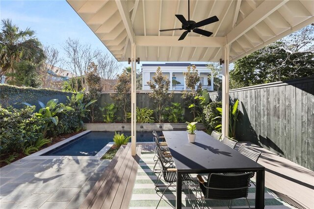 wooden deck with ceiling fan, a patio area, and a fenced in pool