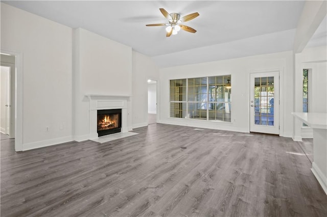 unfurnished living room with ceiling fan, hardwood / wood-style floors, and vaulted ceiling